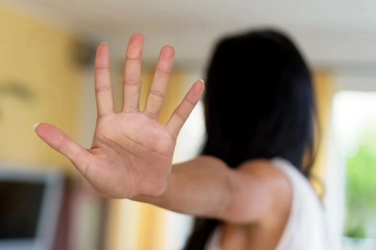 Frau wendet sich ab mit ausgestrecktem Arm und abwehrender Geste