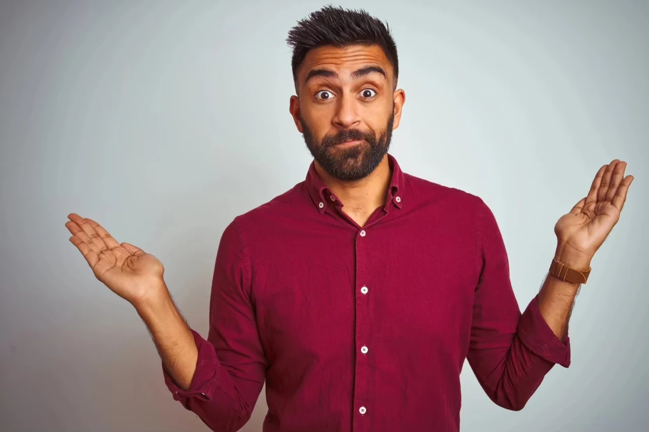 Mann hebt die Hände, als würde er sich entschuldigen wollen, aber sein Gesicht spricht eine andere Sprache