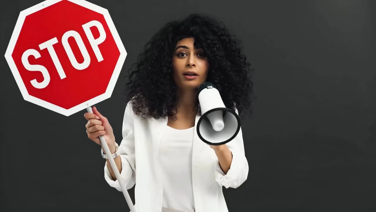Frau hält Stoppschild und Megaphon in den Händen