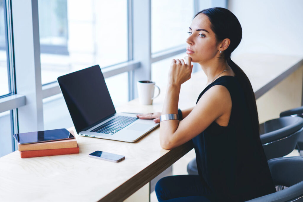 Person sitzt am nachdenklich am Laptop